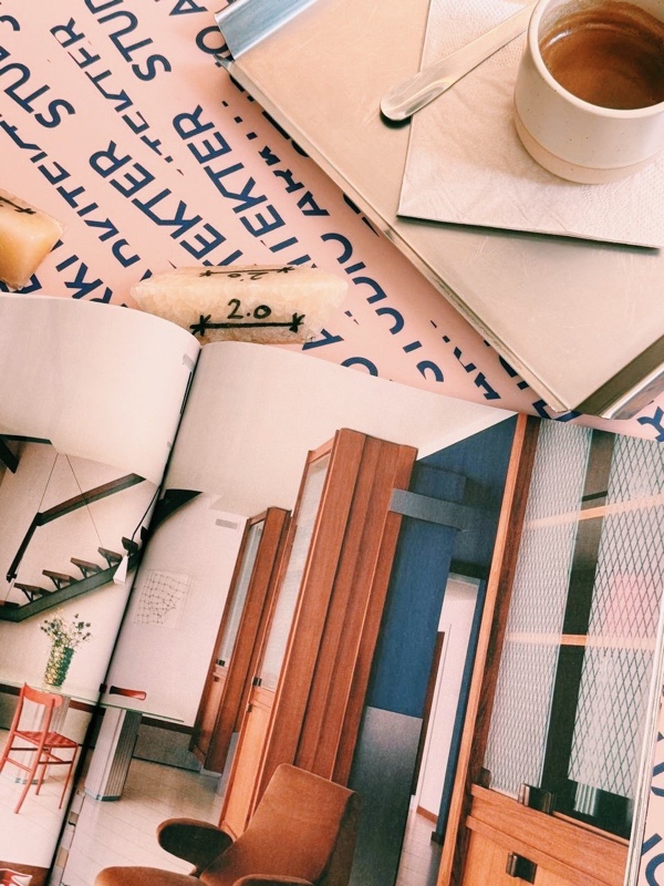 Coffee on a Studio Arkitekter branded mat, architecture magazines