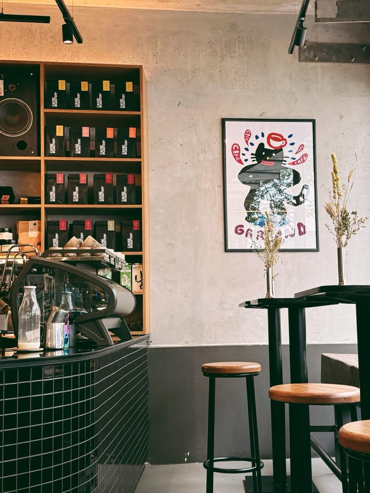 Cafe interior — bean shelves and poster