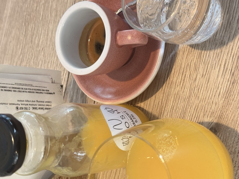 Espresso in a branded cup and fresh orange juice